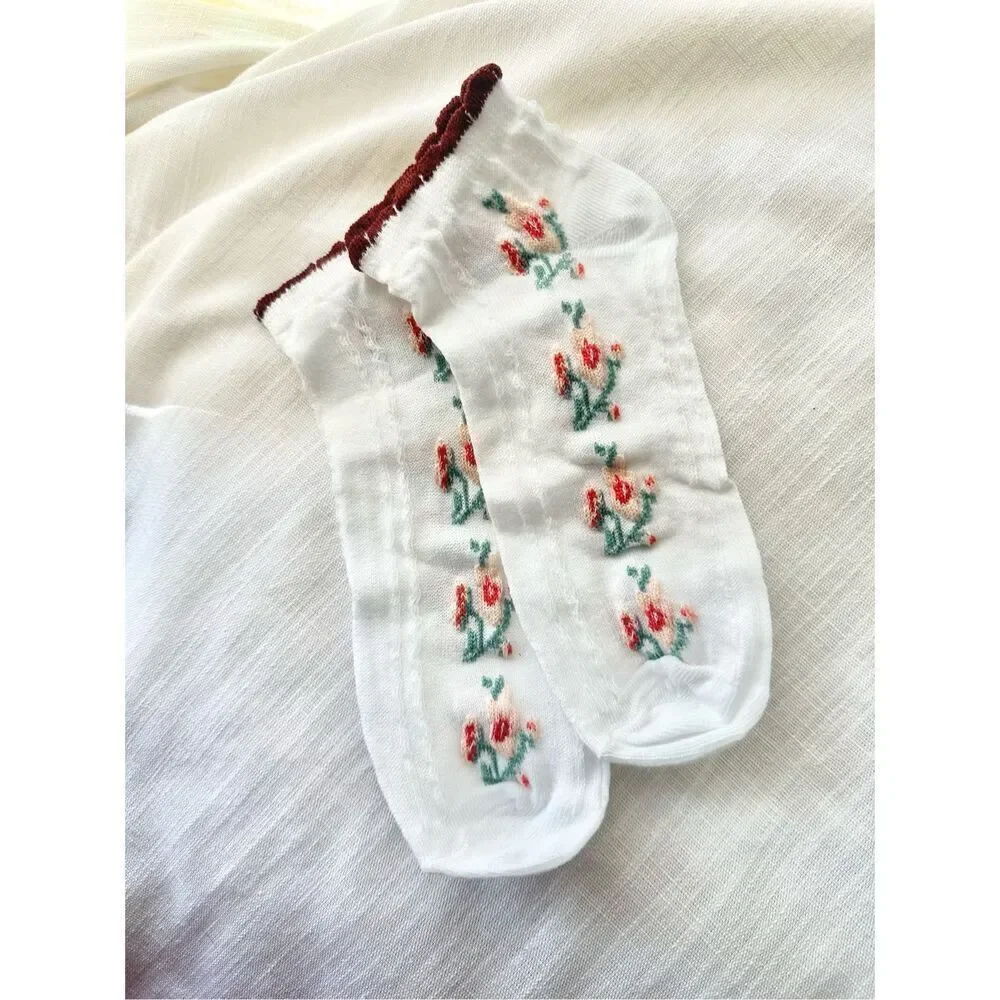 Green, burgundy, pink, and red floral white socks